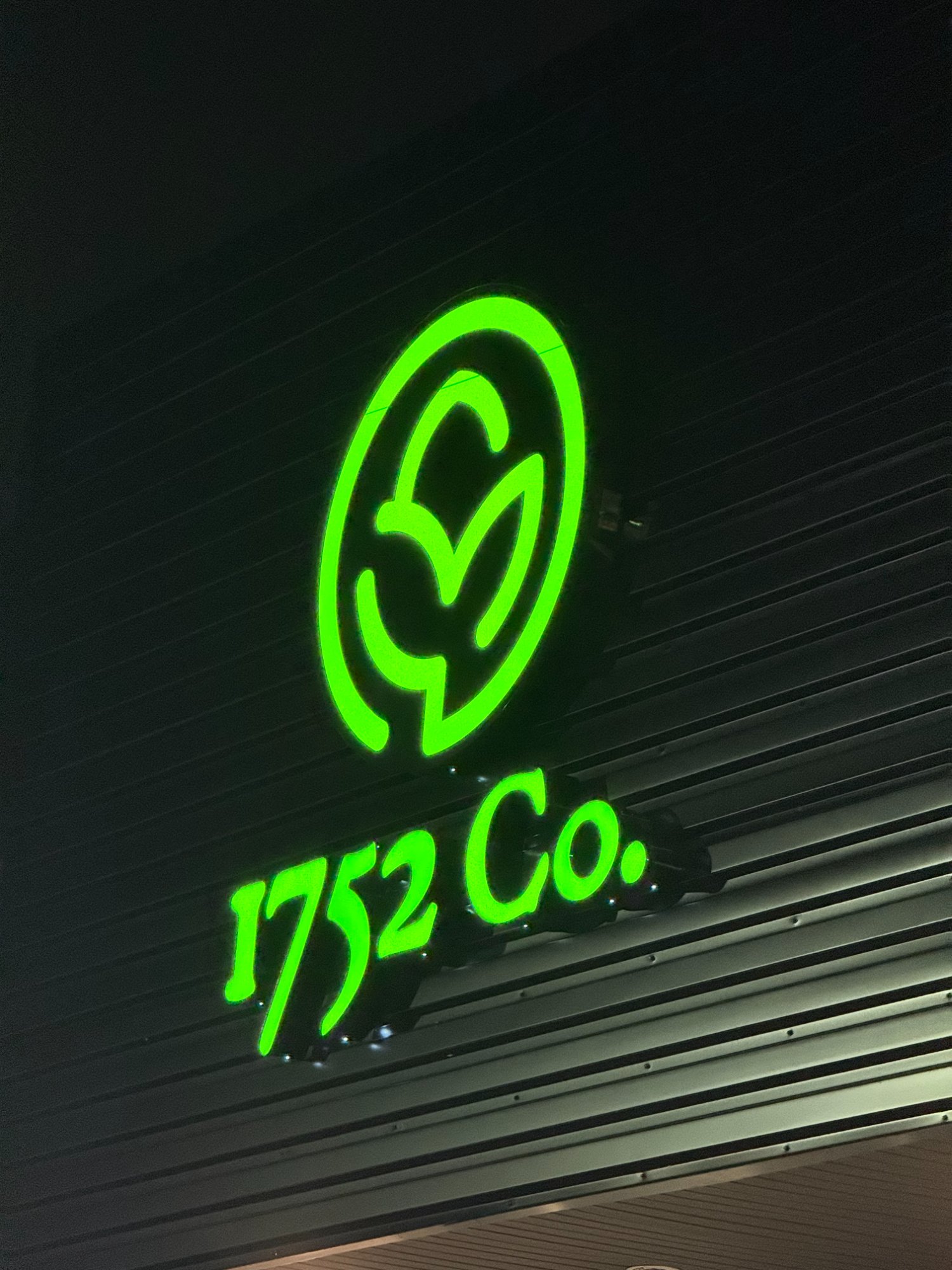 1752 Co. — vibrant green halo back-lit channel letter sign glowing at night