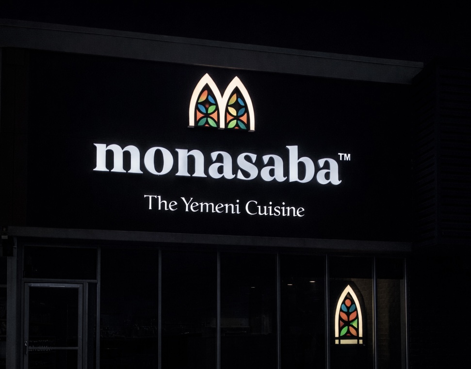 Monasaba — elegant white front-lit channel letters with illuminated decorative logo element